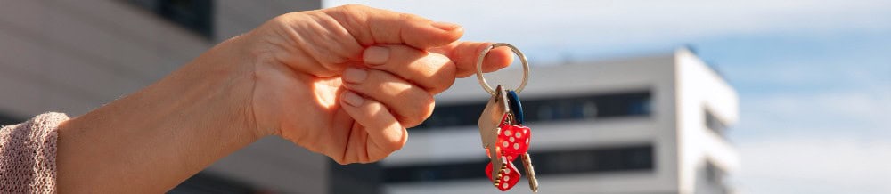Wohnungsschlüssel vor einem Wohnhaus