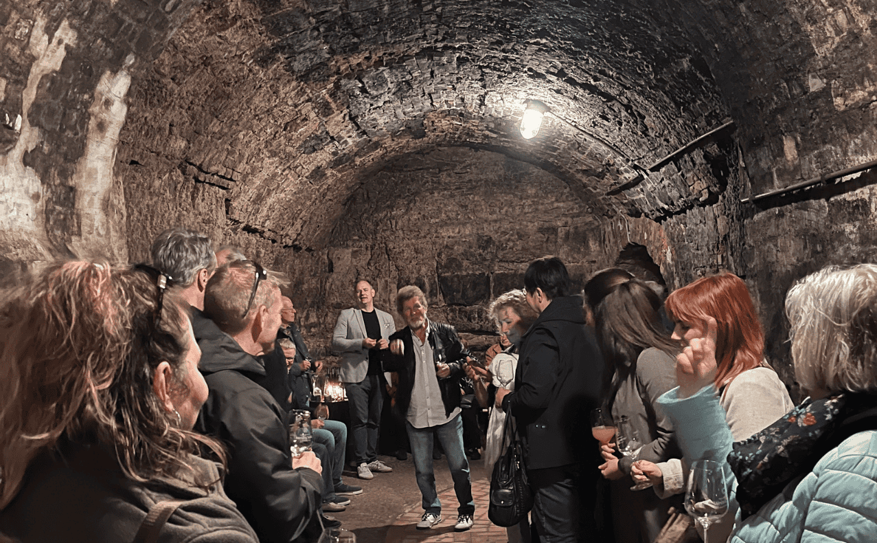 DSW-Mitgliedervertreterfahrt-Sekt-und-Wein-Manufaktur-BB-08 Gruppen von Menschen in einer Kellerbar der Stadtfelder Wohnungsgenossenschaft eG, die an einer Veranstaltung teilnehmen.
