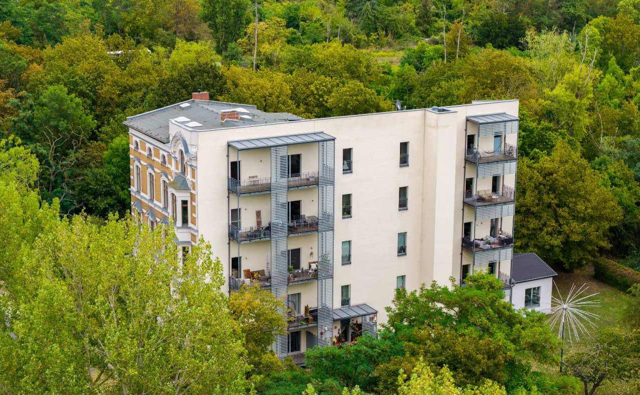 Moderne Wohnanlage auf dem Werder Mehrfamilienhaus mit großem Wandbild, kleiner Stadtmarsch 9, umgeben von Bäumen und Parkplätzen, in Magdeburg.